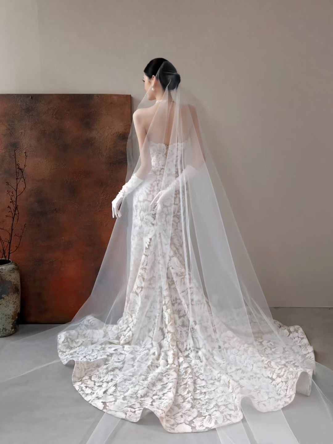 Back view of floral jacquard mermaid wedding dress with long sheer cathedral veil