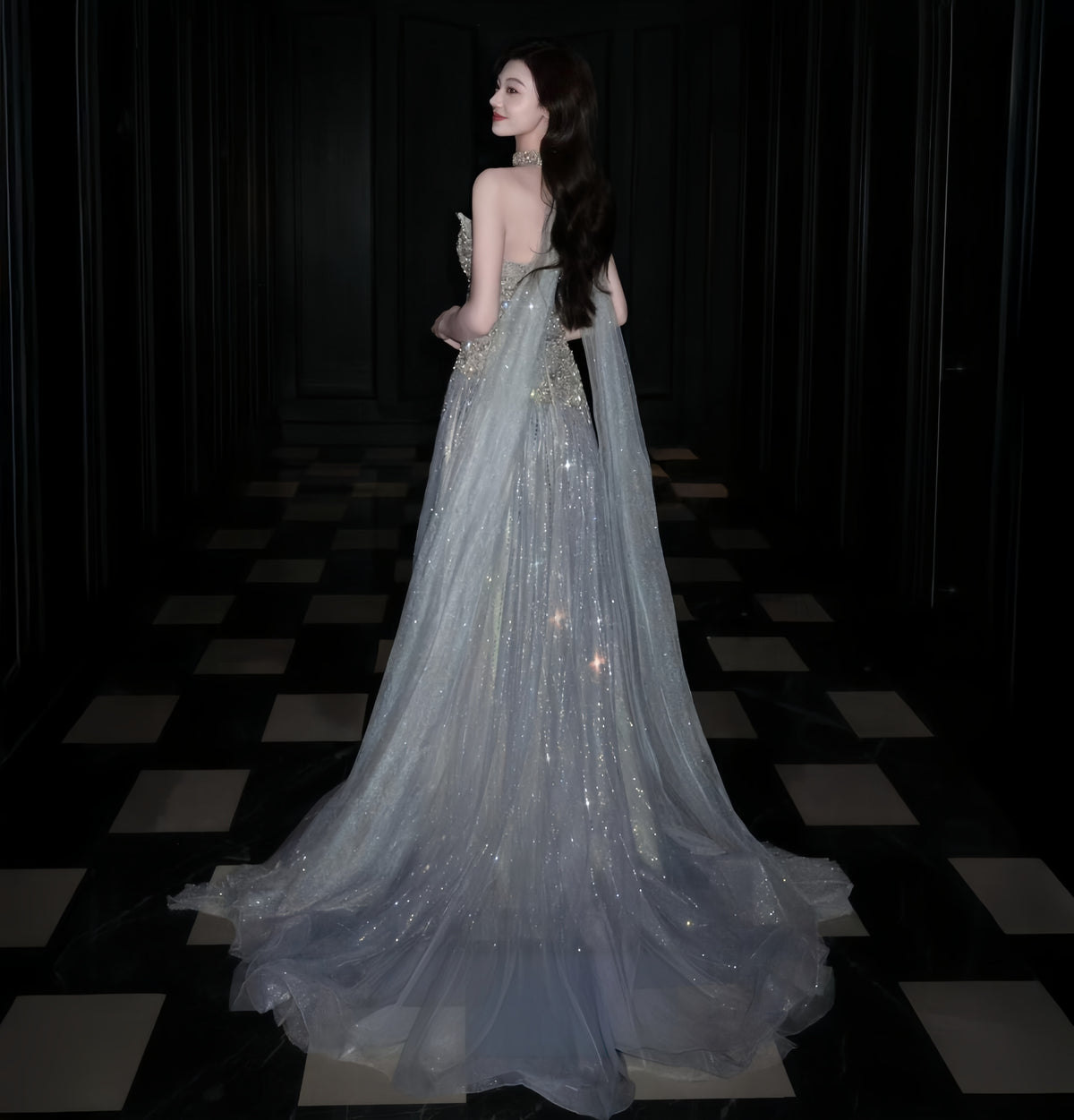 Back view of silver glitter tulle evening gown with flowing cape and sweeping train