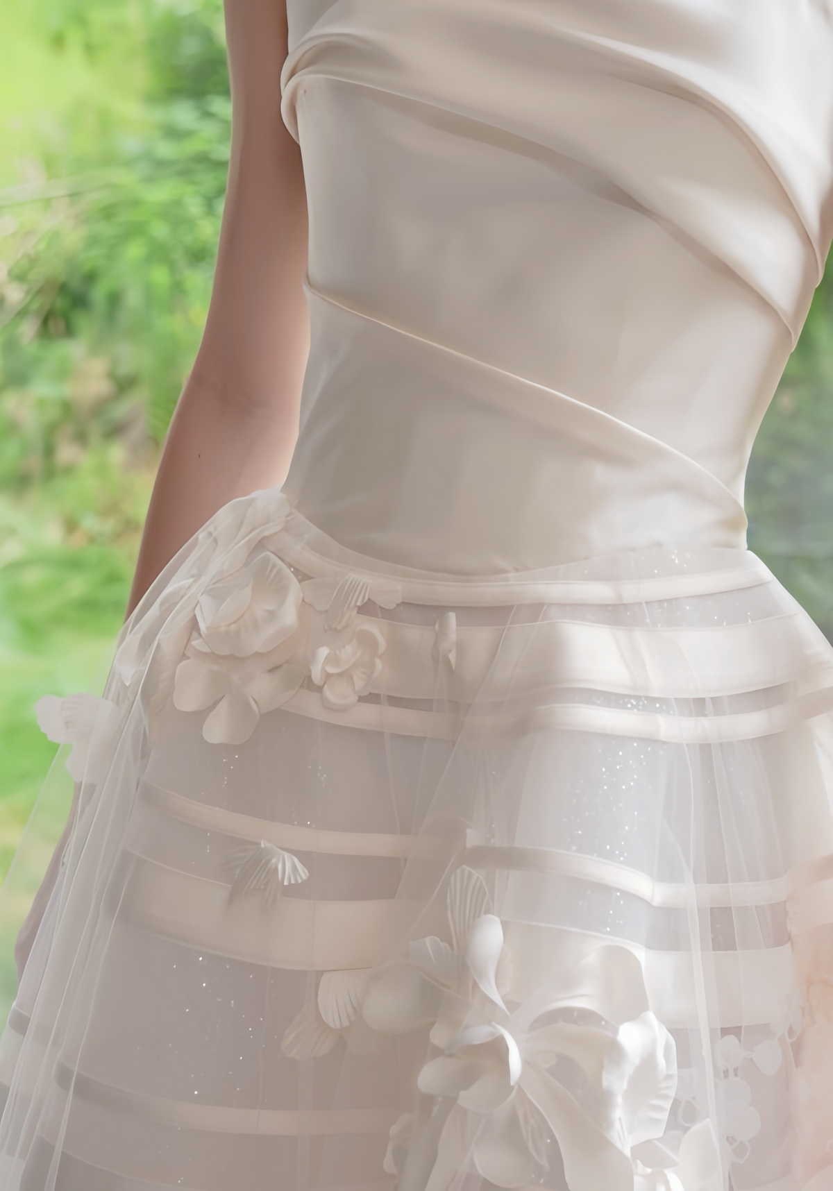 Close-up of 3D floral appliqués and satin ribbon details on an A-line wedding dress