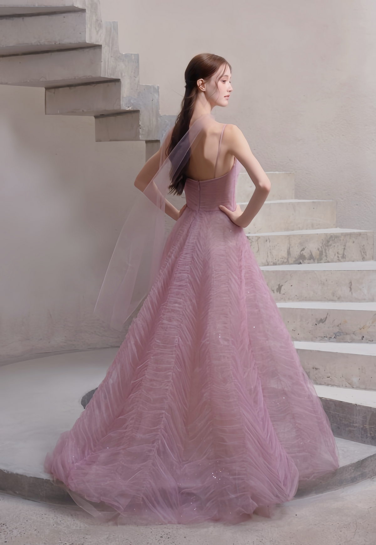 Back view of dusty rose tulle evening gown with open back and flowing sheer scarf