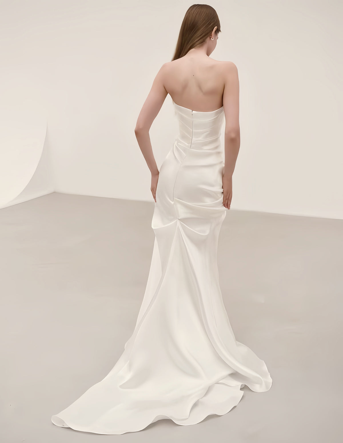 Back view of minimalist satin mermaid wedding dress with fitted silhouette and elegant sweep train