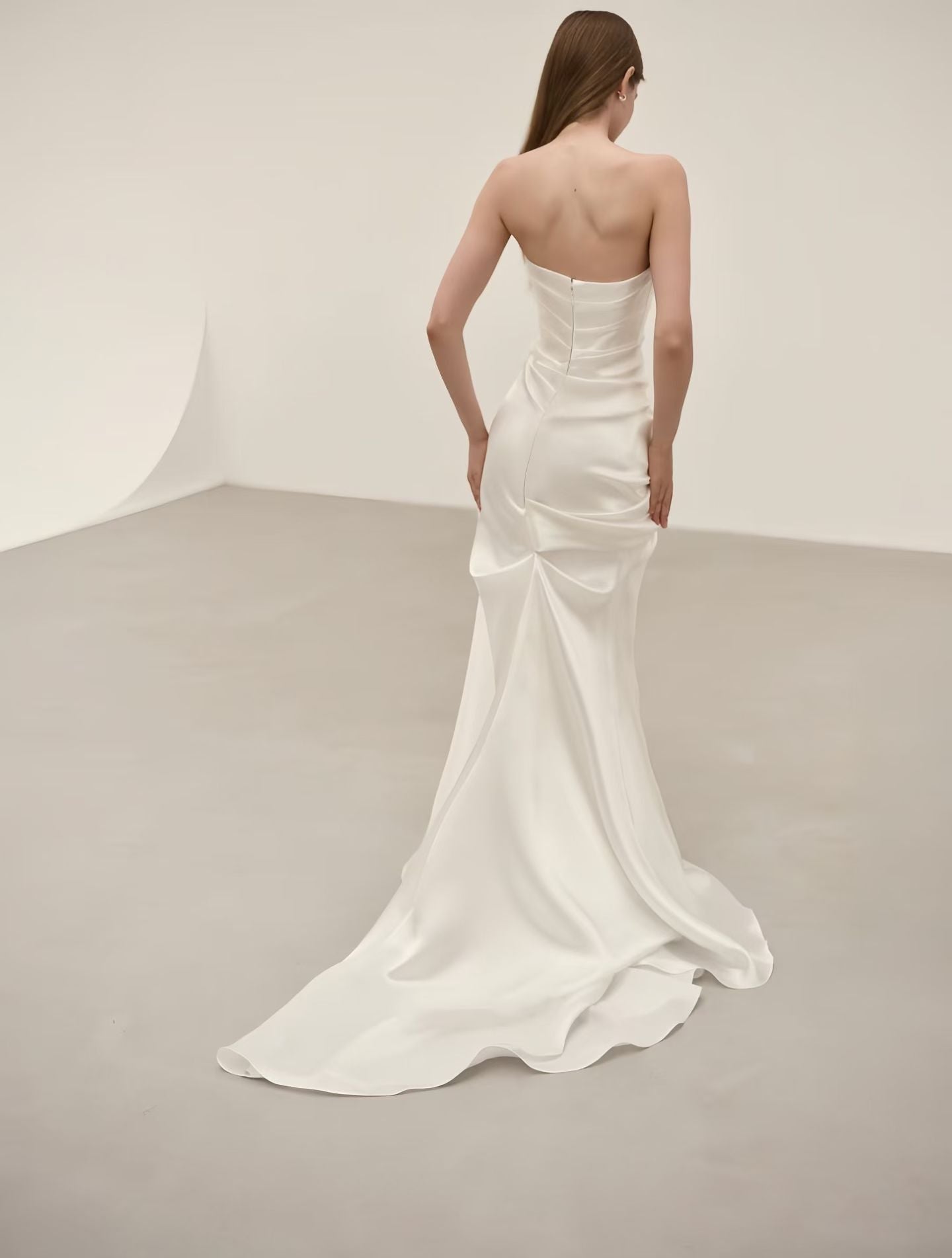 Back view of minimalist satin mermaid wedding dress with fitted silhouette and elegant sweep train
