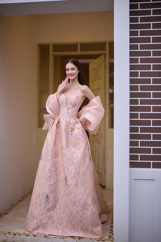 Blush pink A-line wedding dress with sweetheart neckline, floral details and oversized bow accent