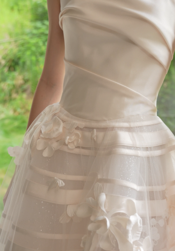 Close-up of 3D floral appliqués and satin ribbon details on an A-line wedding dress