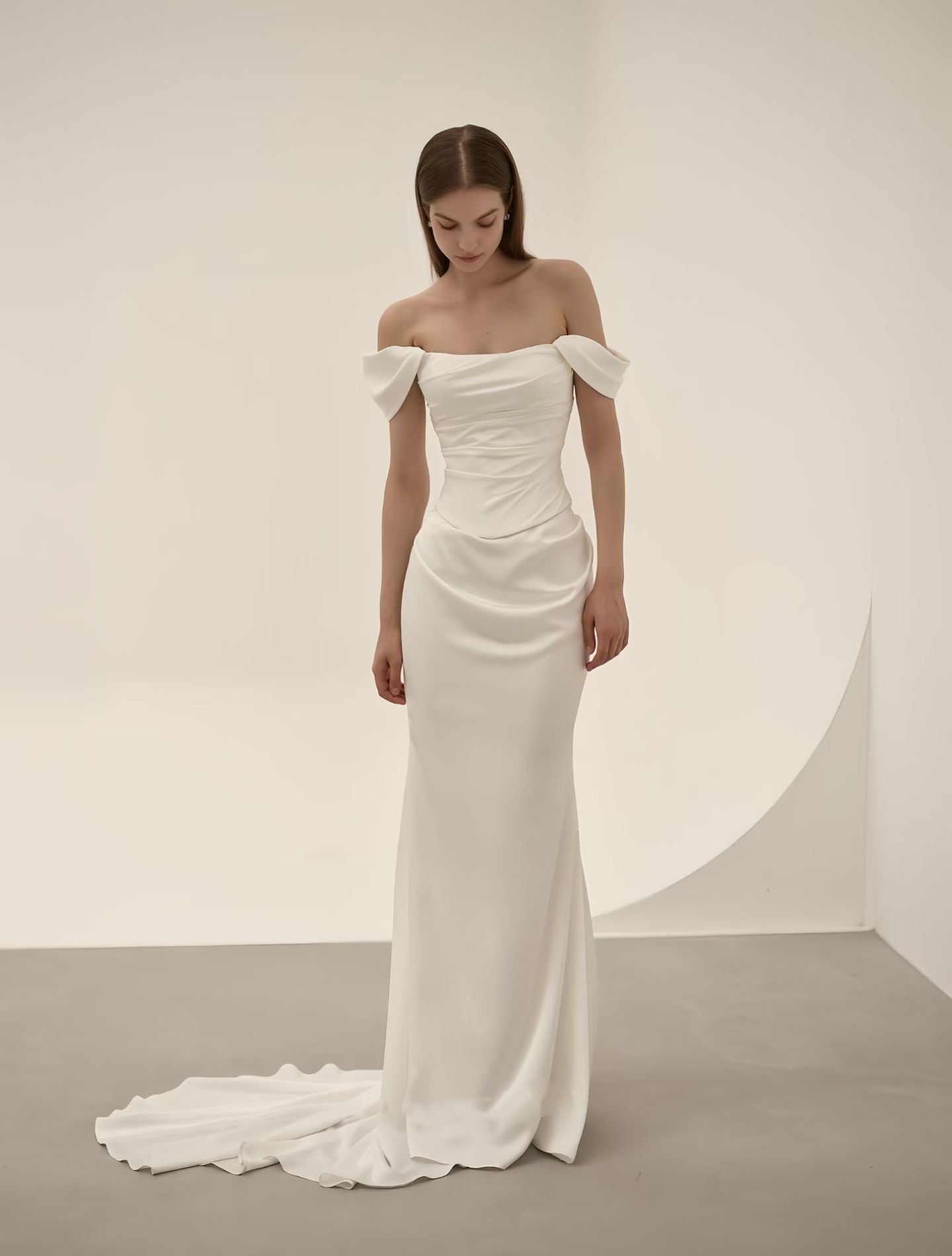 Close-up of off-shoulder bow and ruched satin detailing on a minimalist luxury wedding dress