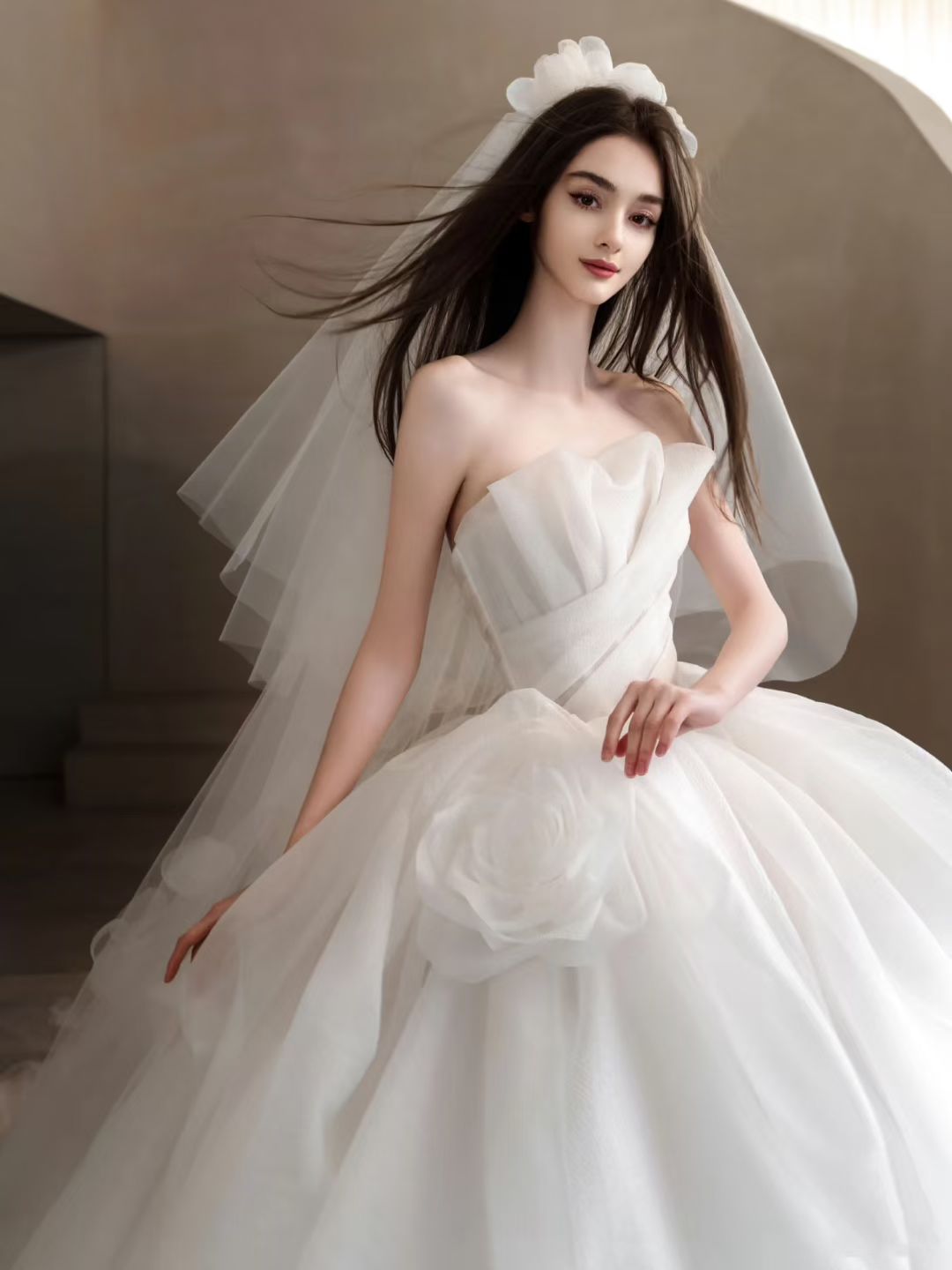 Close view of Luxury strapless organza ball gown wedding dress with layered skirt, floral hip detail and dramatic long train