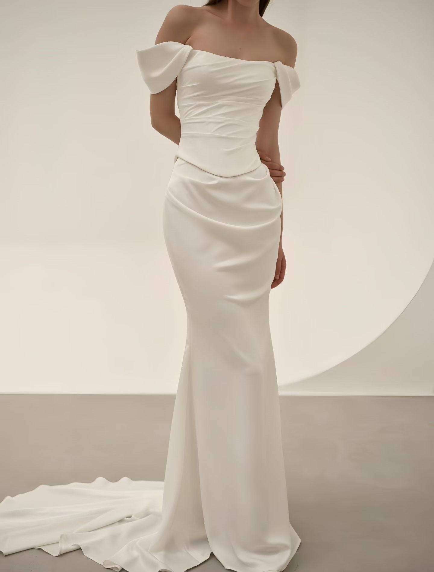 Luxury satin mermaid wedding dress with off-shoulder neckline, oversized bows, ruched bodice and elegant sweep train