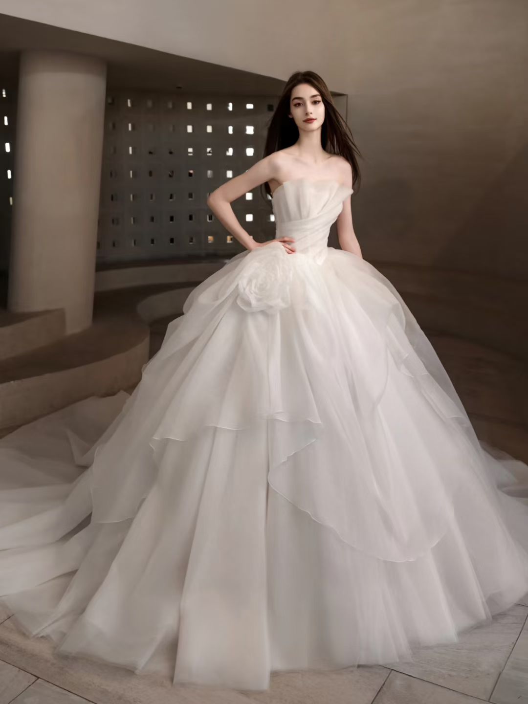 Luxury strapless organza ball gown wedding dress with layered skirt, floral hip detail and dramatic long train