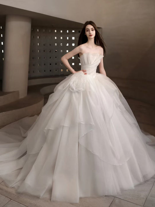 Luxury strapless organza ball gown wedding dress with layered skirt, floral hip detail and dramatic long train