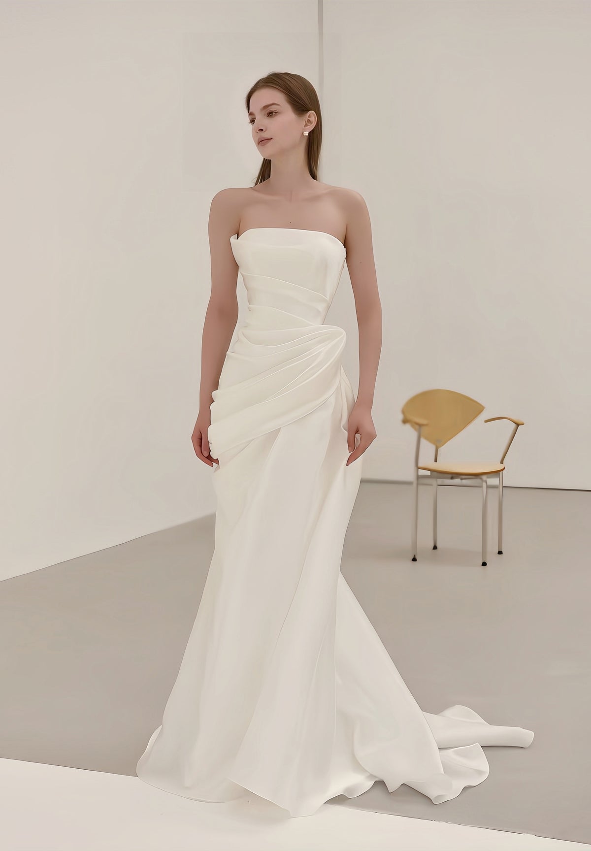 Minimalist draped satin strapless mermaid wedding dress with sculptural waist and sweep train