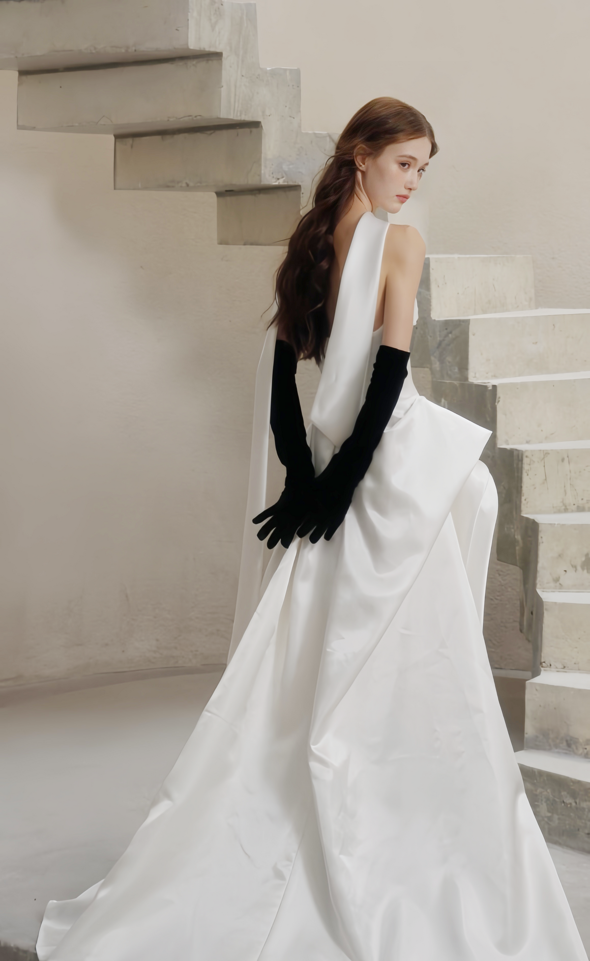 Modern white strapless wedding dress with open back, draped satin skirt and long bridal scarf
