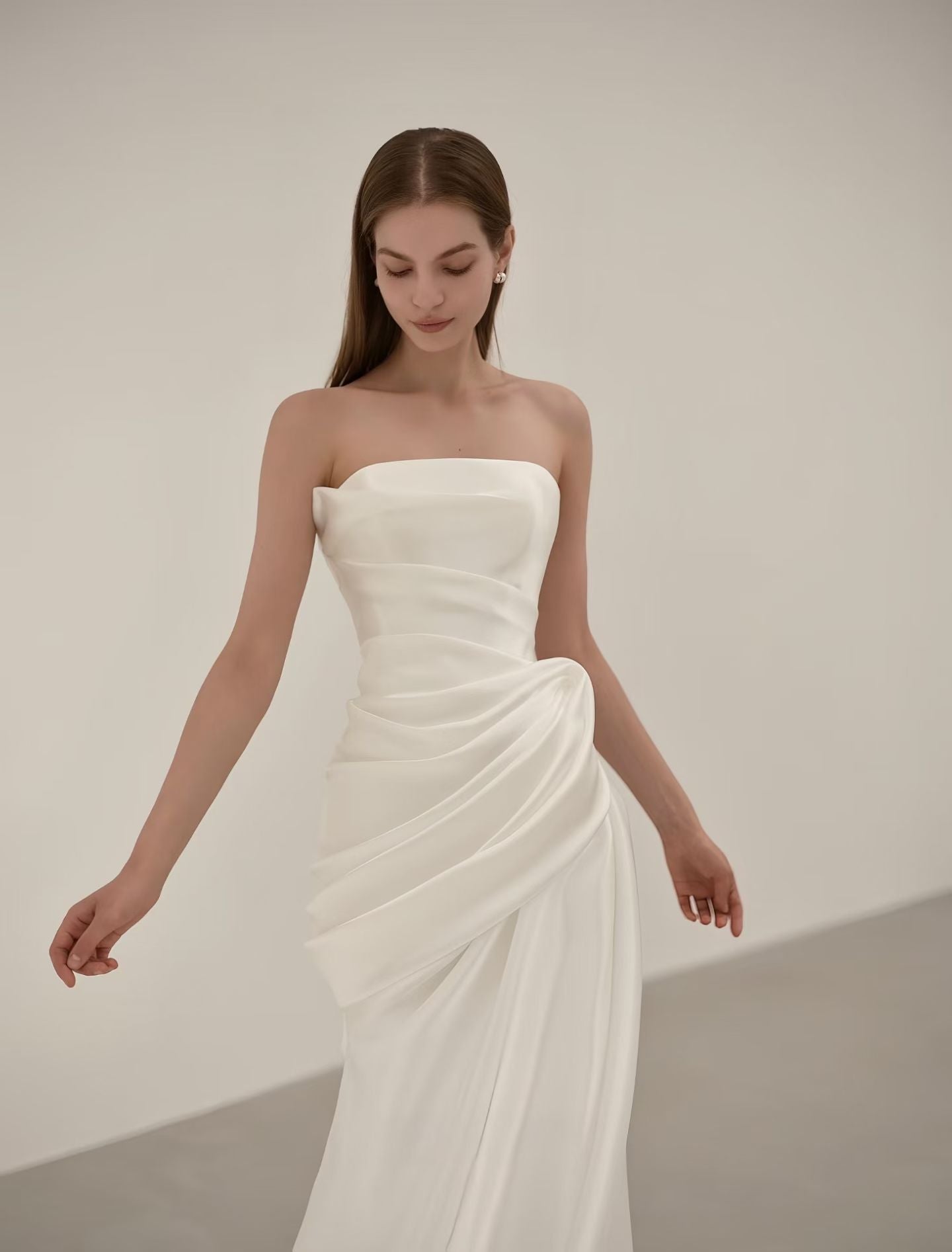 Sculptural draped satin detail on a strapless minimalist mermaid wedding dress