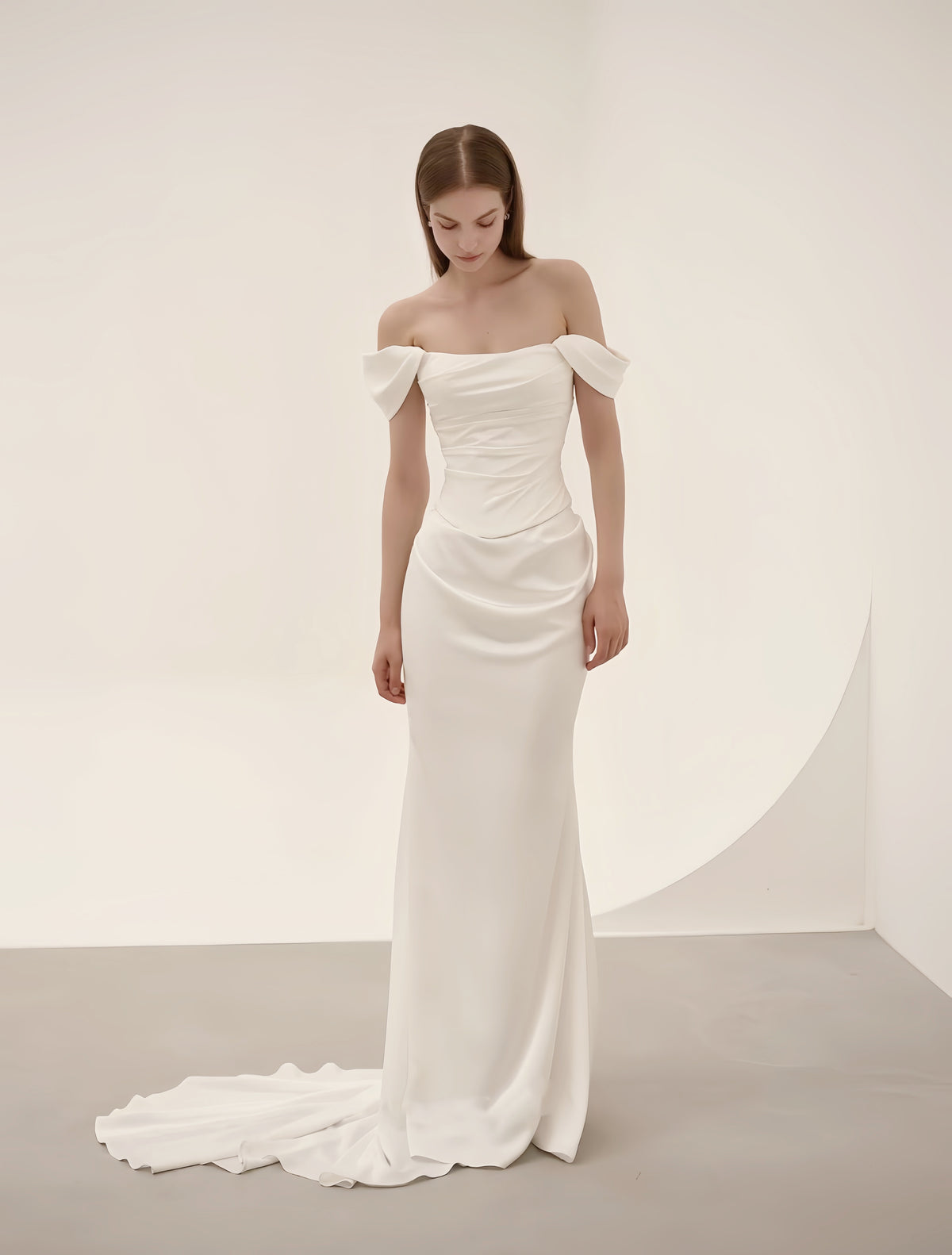 Close-up of off-shoulder bow and ruched satin detailing on a minimalist luxury wedding dress