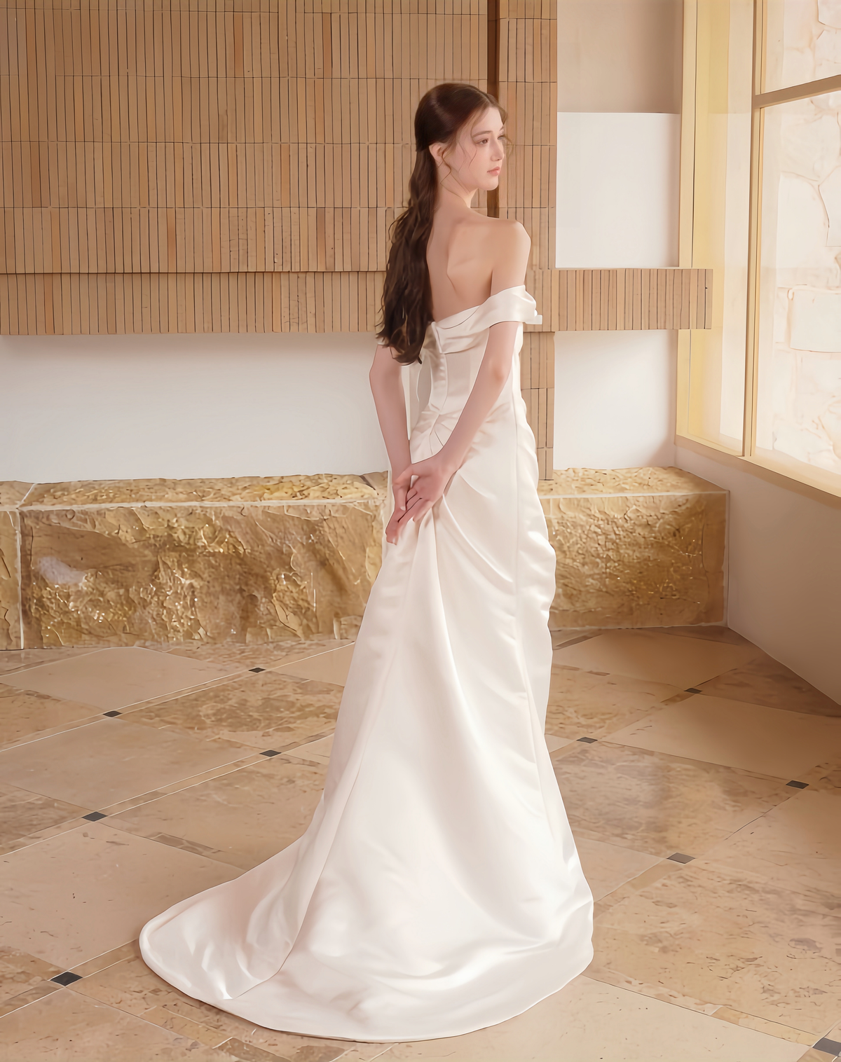 Back view of minimalist satin sheath wedding dress with off-the-shoulder neckline and train